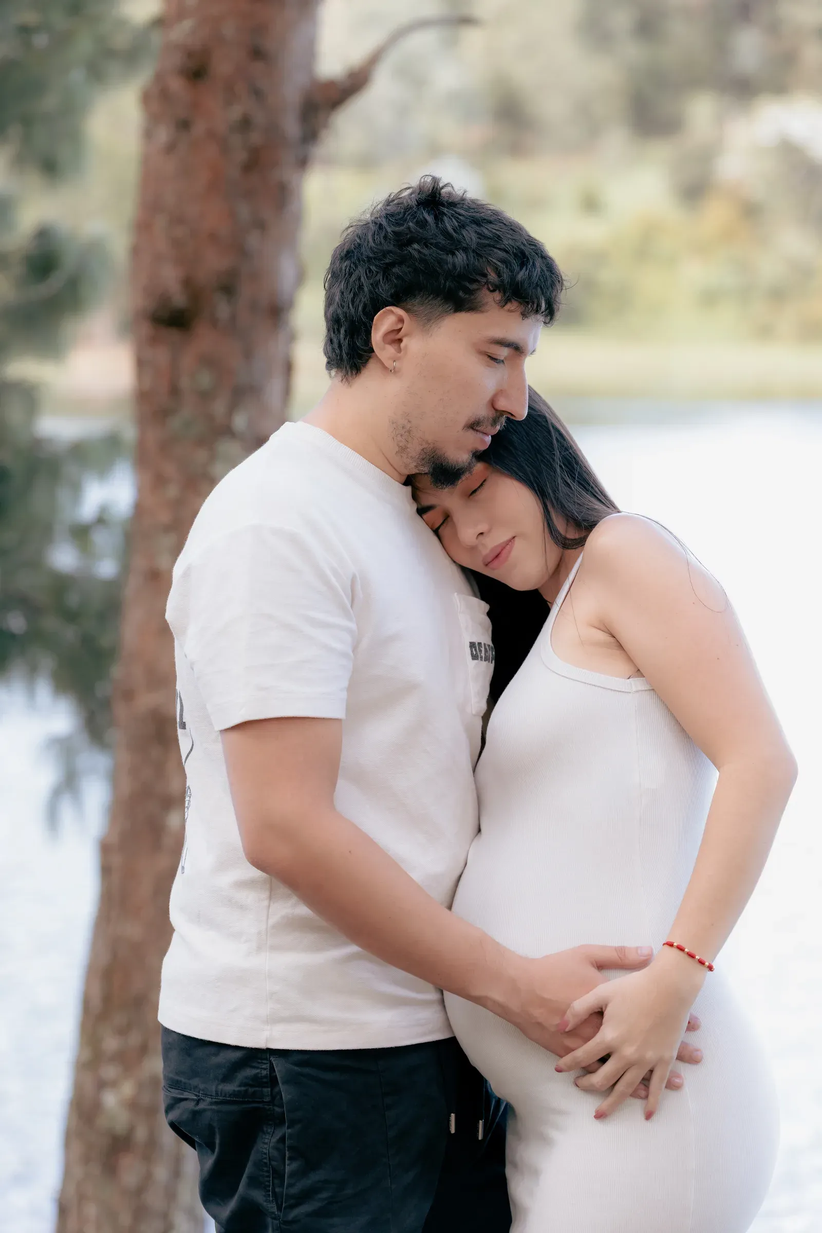 Santiago holding Alejandra in a quiet lake portrait while Aarón grows.