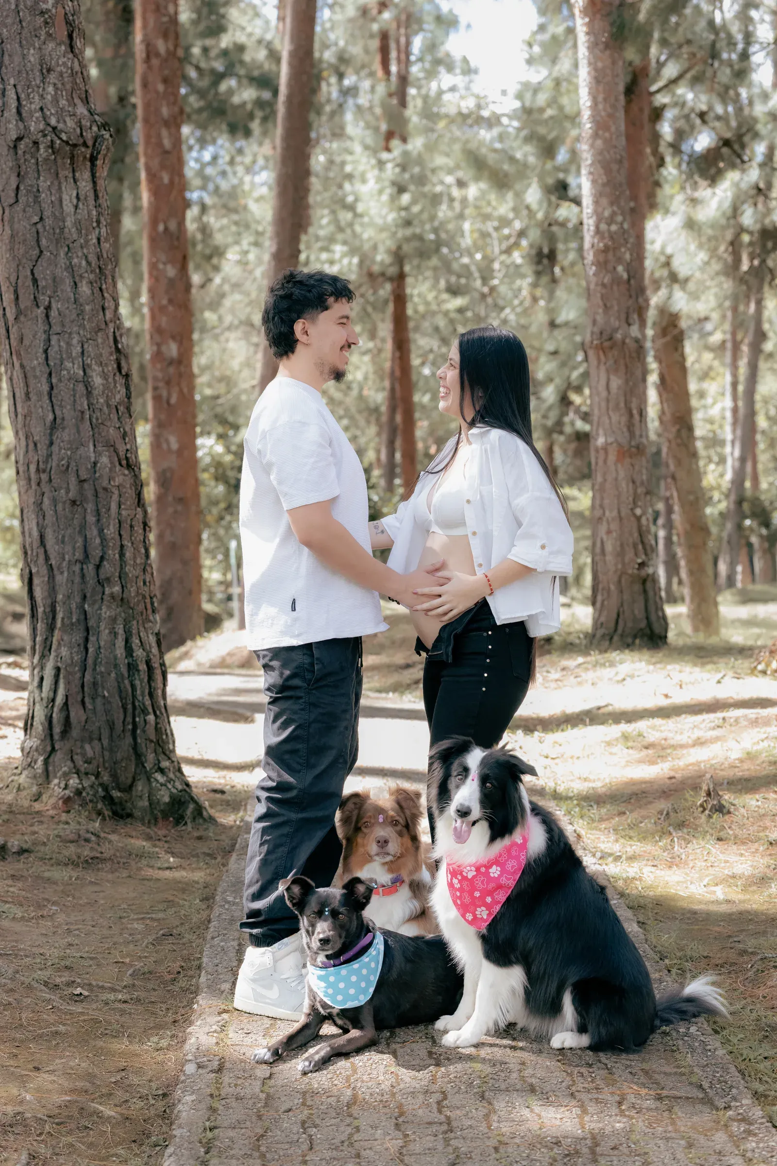 Santiago, Alejandra, Aarón, and the three family dogs together on a forest path.